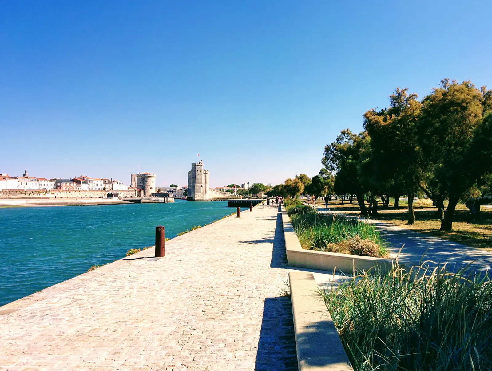 Conciergerie Airbnb La Rochelle — location saisonnière Promenade en bord de mer à La Rochelle avec les tours du Vieux-Port au loin